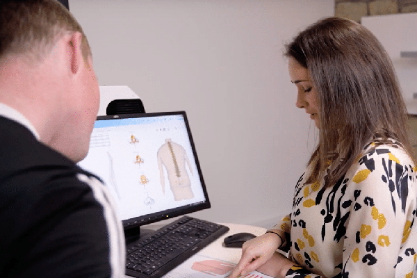 Two colleagues discussing the right scan for their project on a computer screen in an office setting. | FCE Scan